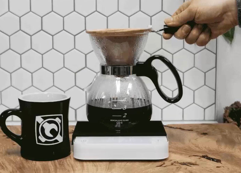 Yama glass brewer beside a coffee cup