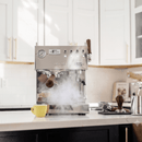 Espresso machine in a kitchen with a yellow cup and various kitchen items.